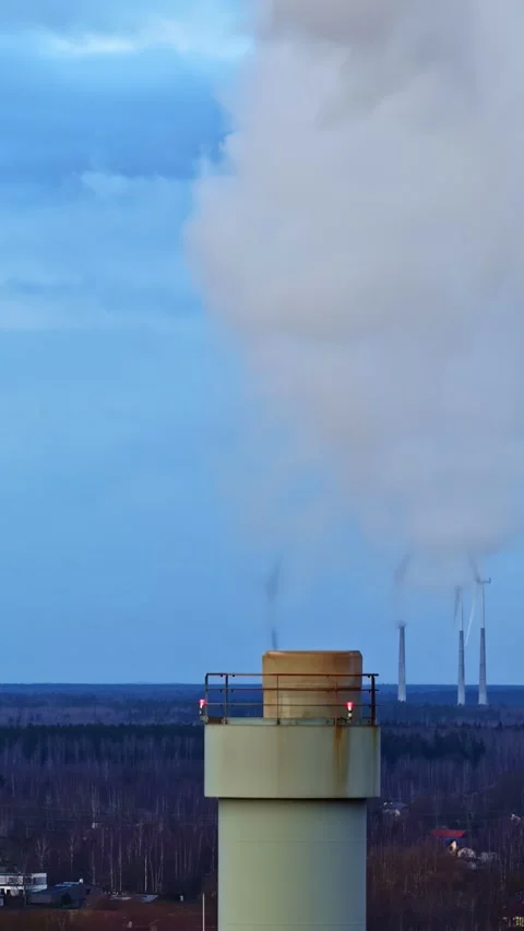Industrial stack releasing a large plume of vapor against a backdrop of wind Stock Footage 337605202