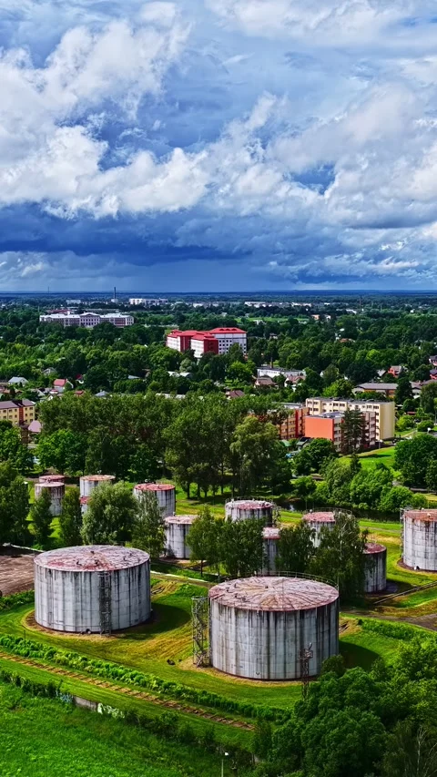 Industrial Storage Tanks Beneath Dramatic Clouds on City Outskirts Stock Footage 337387297