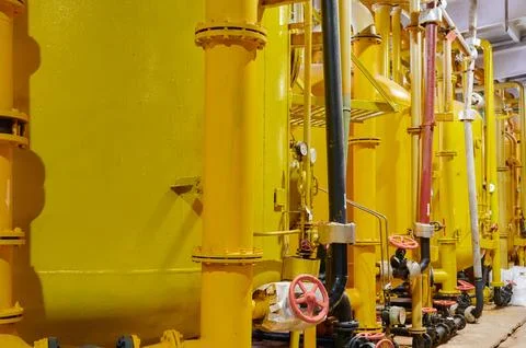 Industrial storage tanks in a processing facility showcasing yellow color and Stock Photos