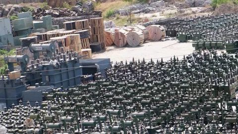 Industrial storage yard with rows of electrical transformers and cable reels Видео 329854706