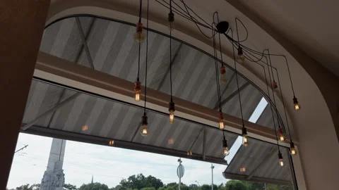 Industrial style cafe interior with curved glass wall, hanging filament bulbs Stock Footage 345126932
