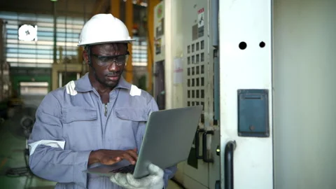 Industrial technician using a laptop computer to monitor machinery systems Stock Footage 339209314