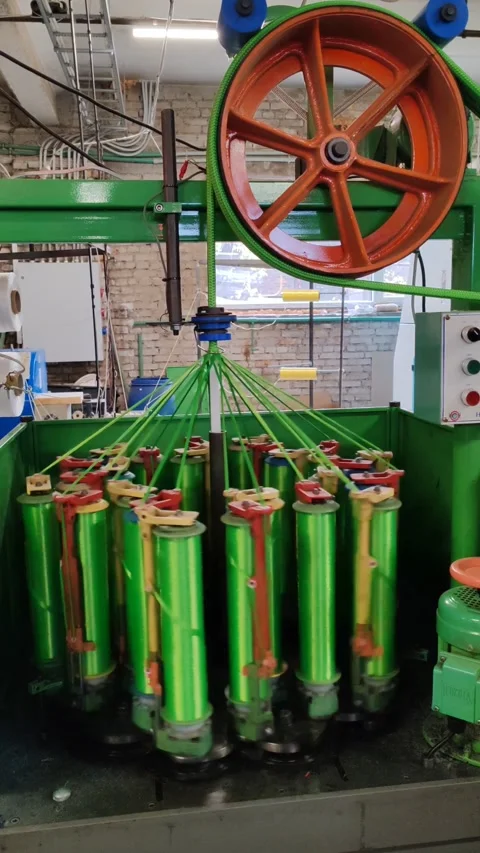 Industrial textile machine spinning bright green threads in a factory setting Stock Footage 293147307