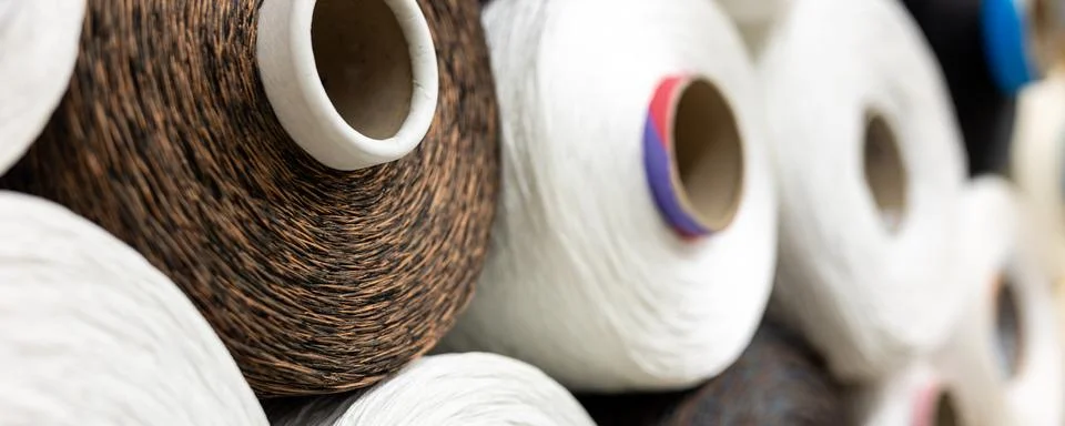 Industrial textile thread spools stacked warehouse fiber production materials Stock Photos