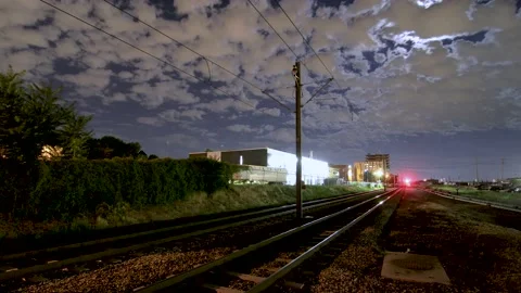 Industrial Train Yard Under Full Moon in Night Time-Lapse with Moving Light Trai Stock Footage 162420037