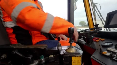Industrial Vehicle Operator Using Controls Inside Cab in High-Visibility Stock Footage 337976250