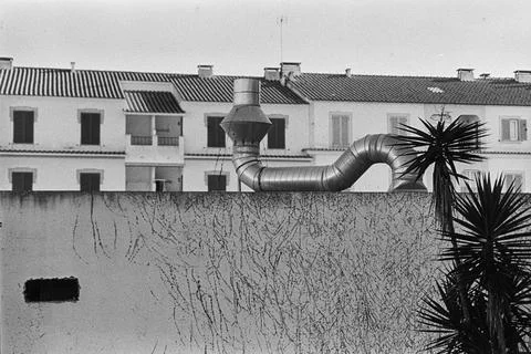Industrial Vent Pipe Against Patterned Urban Facade Fotos Stock