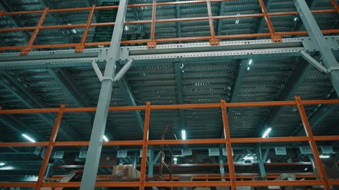 Industrial warehouse interior with multi-tier steel pallet racking and orange Stock Footage 335861482