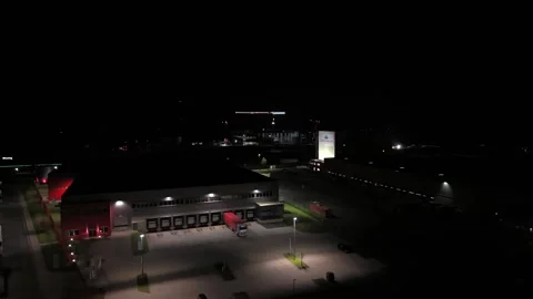 Industrial warehouse at night, with trucks at loading docks, illuminated ramps Video stock 332622553