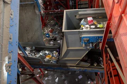 Industrial waste sorting conveyor system with mixed garbage and plastic in Stock Photos