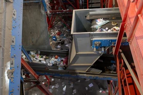 Industrial waste sorting conveyor system with mixed garbage and plastic in Stock Photos
