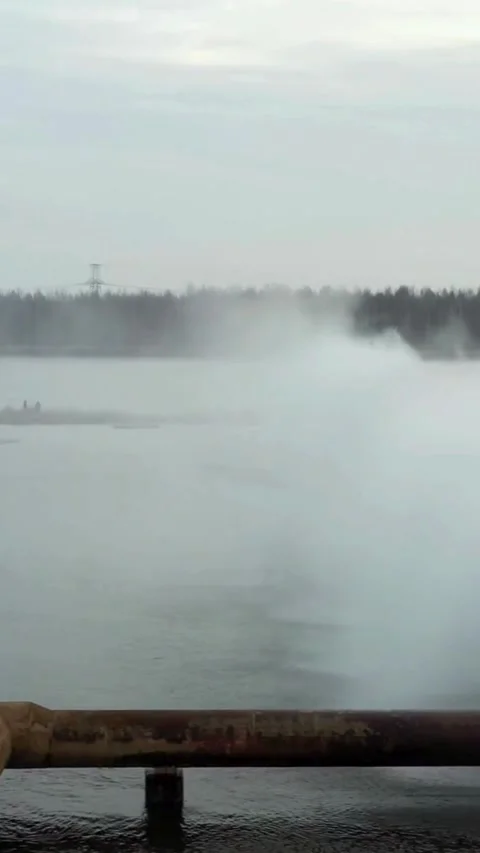 Industrial water cooling system spraying in large pond Stock Footage 334169064