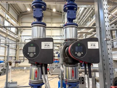 An Industrial water pump system inside a modern facility. Foto stock