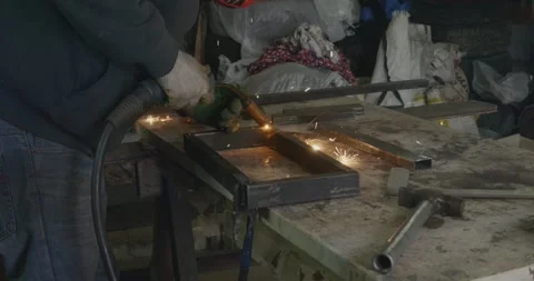 Industrial welder using a welding machine to connect metal profiles, creating a Stock Footage 332373528