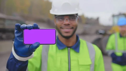 Industrial worker of construction site with mobile phone looking and smiling at Stock Footage 124308434