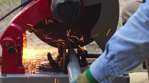Industrial worker cutting metal pipe with a chop saw Stock-Footage 336235177