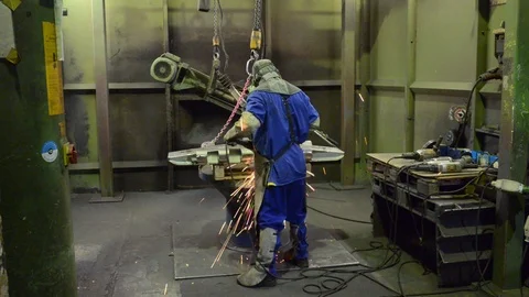 Industrial worker in a foundry machining a workpiece with a grinding machine Stock-Footage 94853485