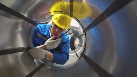 Industrial worker inspecting inside a large metal tube Stock Footage 317903018