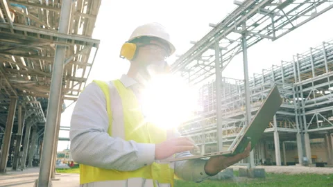 Industrial worker is operating a laptop outside of the oil refinery Video stock 160163962