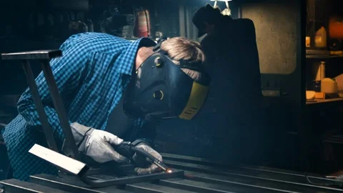 Industrial worker in protective mask using modern machine for welding metal Stock Footage 121876606