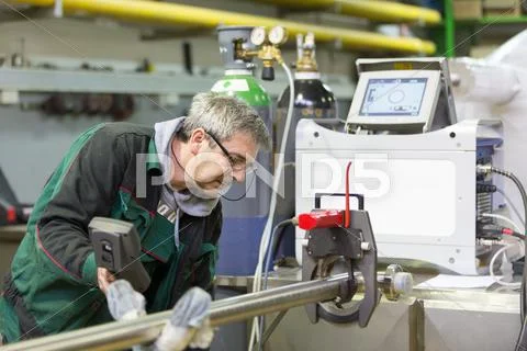 Industrial worker setting orbital welding machine. Stock Photos