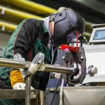 Industrial worker setting orbital welding machine. Industrial operator set... Stock Photos