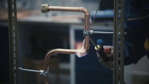 Industrial worker soldering copper pips Stock Footage 79089832