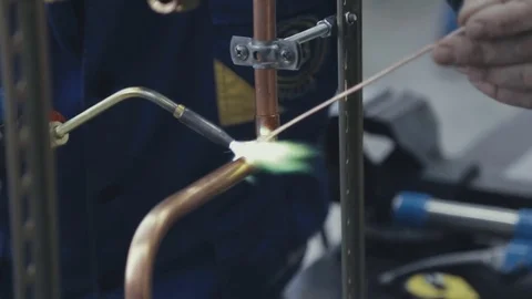 Industrial worker soldering copper pips Stock Footage 79089981