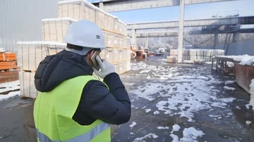 Industrial worker talking on cell phone at the factory for food production Stock Footage 85570640