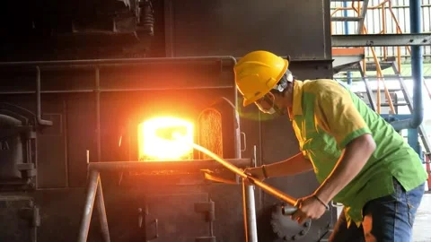 Industrial Worker Tending to High Temperature Furnace in Factory Stock Footage 334320253