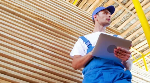 Industrial worker in uniform checking large wooden box on tablet in warehouse Stock Footage 57094926
