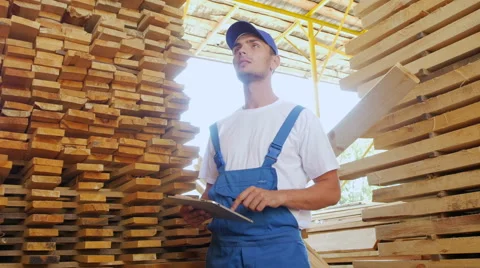 Industrial worker in uniform checking large wooden box on tablet in warehouse Stock Footage 57095052