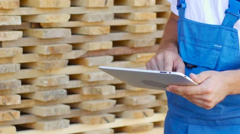 Industrial worker in uniform checking large wooden box on tablet in warehouse Stock Footage 57096676