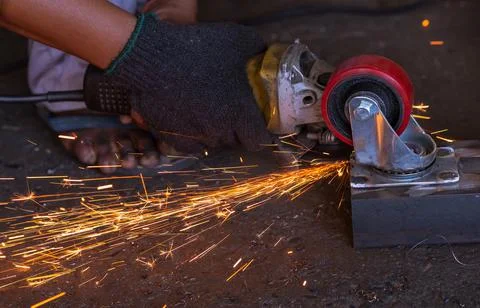 Industrial worker using angle grinder cutting metal. Worker working with angl 스톡 사진