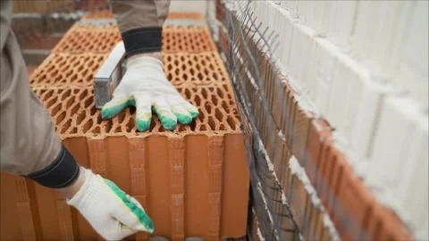 Industrial worker using trowel and tools for building exterior walls with bri Stock Photos