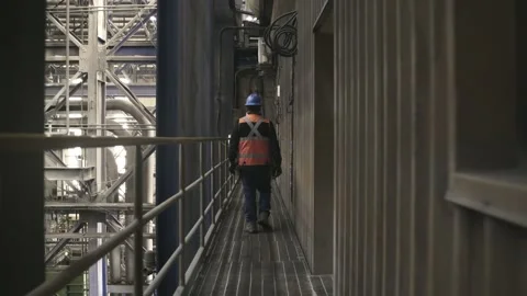Industrial Worker Walking Through Processing Facility at El Teniente Mine Stock Footage 339378251