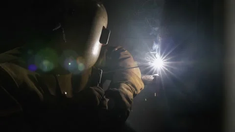 A industrial worker in welding helmet using stick welder Stock Footage 155537306