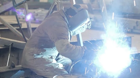 Industrial worker welds a metal frame Stock Footage 87908044