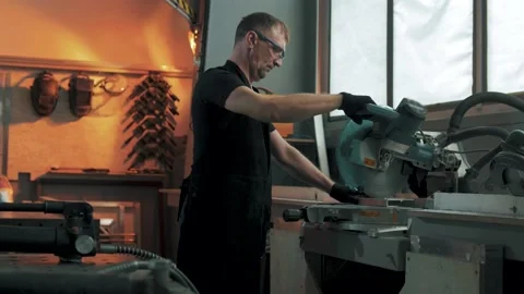 Industrial worker on a work shift at a circular saw on a machine cutting Stock Footage 179687220