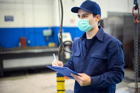 Industrial worker writing on a document Stock Photos