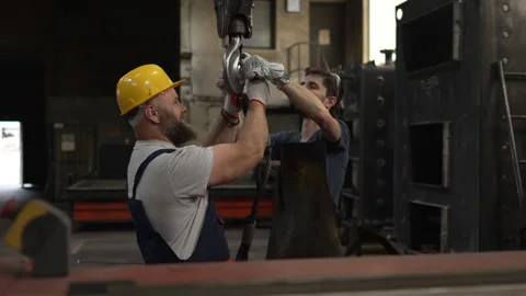 Industrial workers attaching a steel cable to a crane hook Video stock 334723196
