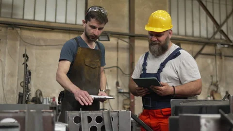 Industrial workers discussing project plans in a metal factory Video stock 334722854