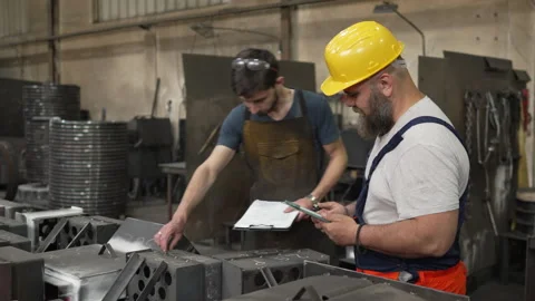 Industrial workers discussing project plans in a metal factory Stock-Footage 334722964