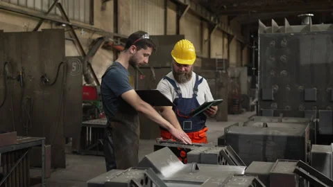 Industrial workers discussing project plans in a metal factory Video stock 334723010