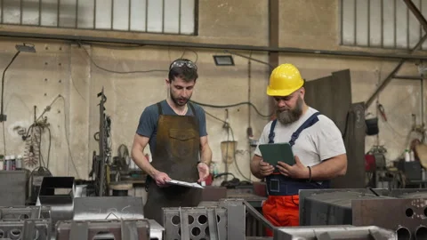 Industrial workers discussing project plans in a metal factory 스톡 동영상 334723011