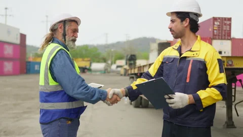 Industrial workers shaking hands to finalize a freight agreement at a cargo Stock Footage 342280713