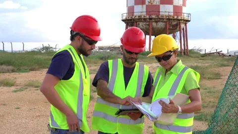 Industrial workers working in front of a refinery Stock Footage 228501015