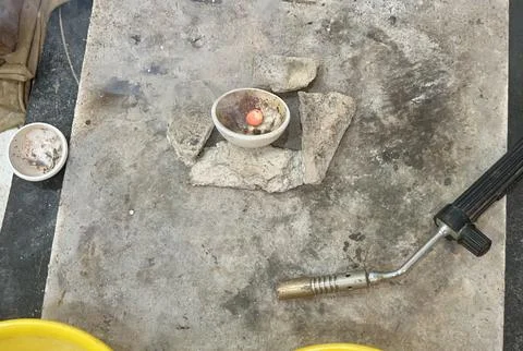 Industrial workshop table with blowtorch tool and metal components Stock Photos