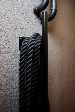 Industrial workspace with tactile elements, Black cord hanging on metallic hook Stock Photos