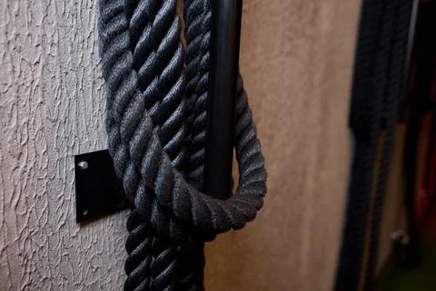 Industrial workspace with tactile elements, Black cord hanging on metallic hook Stock Photos